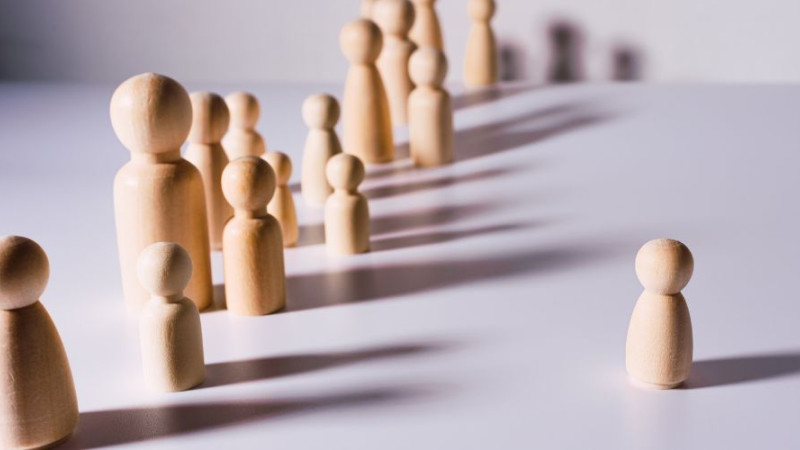 Des figurines en bois de différentes tailles et la portée de leur ombre.