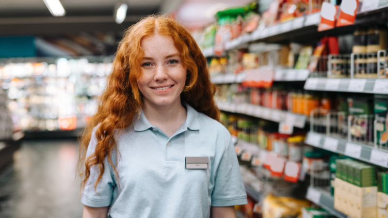 Une jeune fille souriante dans une épicerie.