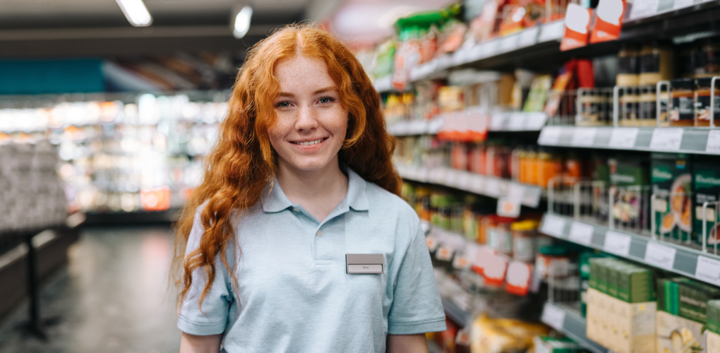 Une jeune fille souriante dans une épicerie.