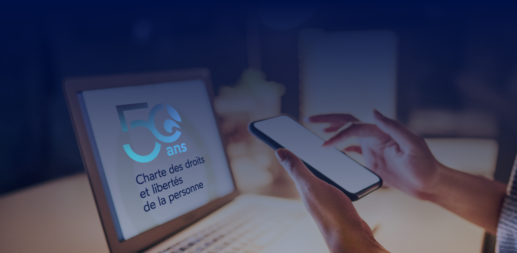 Une personne dont on distingue les mains tient un téléphone. On voit aussi l'écran d'un ordinateur portable sur lequel apparait le logo du 50e de la Charte.