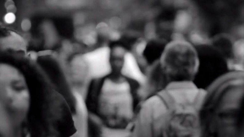 Photo en noir et blanc et floutée de personnes dans une foule.