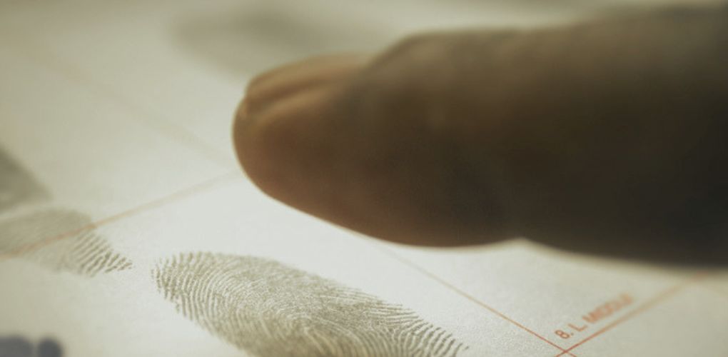 Un doigt en gros plan laissant son empreinte digitale dans un formulaire.
